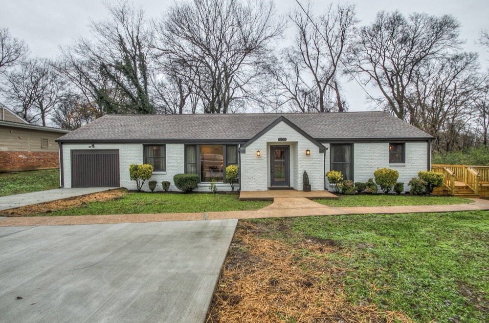 Single-story ranch painted white with dark shutters