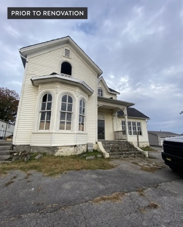 The same Victorian before renovation, with worn white siding
