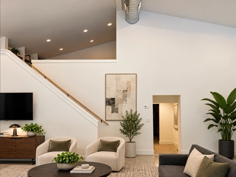 Vaulted living area with stair and white walls